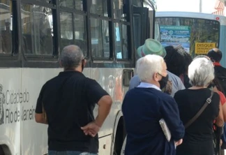 Pessoas esperam em ponto de ônibus no centro do Rio de Janeiro