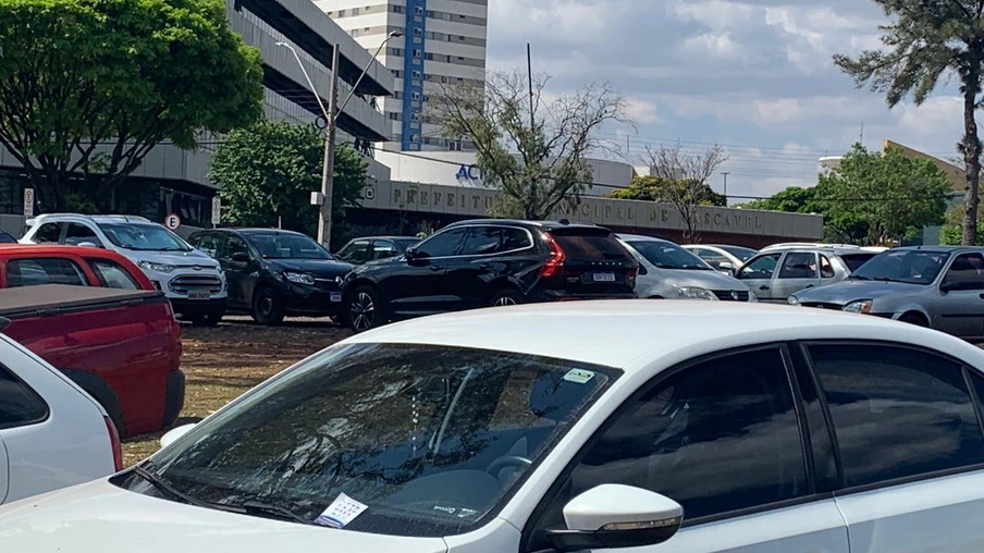 Carros são levados de estacionamento na frente da prefeitura