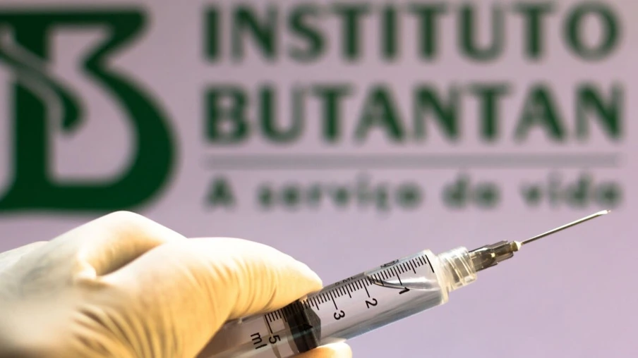 BRAZIL - 2020/11/10: In this photo illustration a medical syringe seen with an Instituto Butantan company logo displayed on a screen in the background.
Sinovac and Butantan Institute are testing the vaccine in Brazil. (Photo Illustration by Rafael Henrique/SOPA Images/LightRocket via Getty Images)
