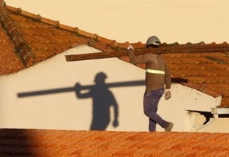 Trabalhadores da construção civil, operários reformam telhado de imóvel em obras no Centro do Rio.