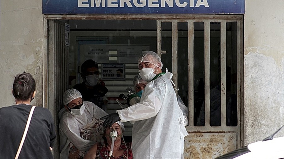 Health workers enter a patient to the Emergency room of the public hospital in Manacapuru, Amazonas state, Brazil, on January 20, 2021. - Cylinders entering and leaving hospitals is the image that can repeatedly be seen in the hospitals in the Brazilian state of Amazonas, where the oxygen crisis unleashes constant tension. (Photo by MARCIO JAMES / AFP)