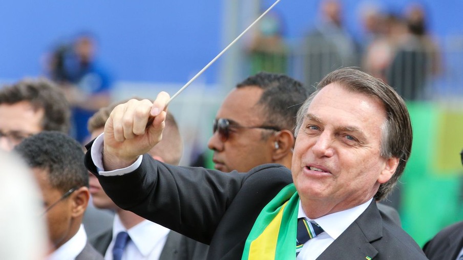 O presidente Jair Bolsonaro,quebra o protocolo desce do palanque, pega uma batuta e faz gestos de maestro ao se aproximar a pé, das arquibancadas onde fica o público na Esplanada dos Ministérios