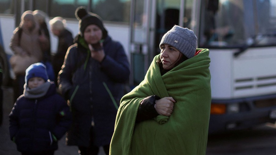 A woman wrapped in a blanket stands as refugees from Ukraine cross the Ukrainian-Slovakian border following Russia's invasion of Ukraine, in Vysne Nemecke, Slovakia, March 3, 2022. REUTERS/Lukasz Glowala